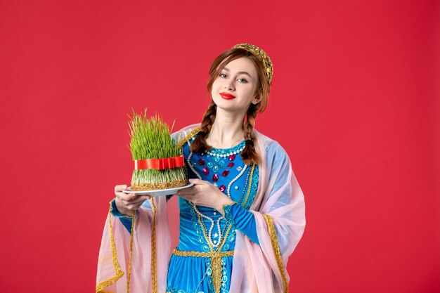 Portrait of beautiful azeri woman in traditional dress with semeni on red