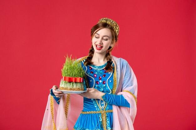 Portrait of beautiful azeri woman in traditional dress with semeni on red