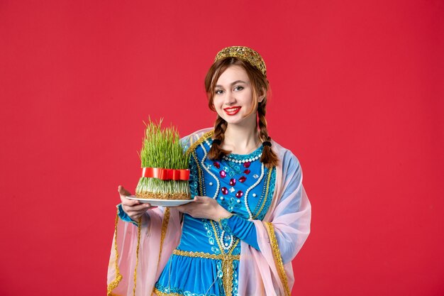 Portrait of beautiful azeri woman in traditional dress with semeni on red