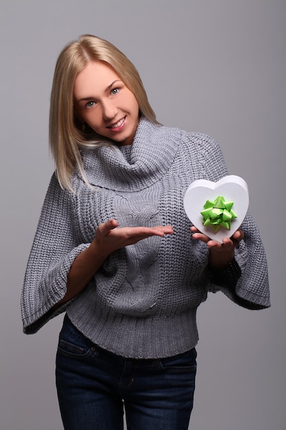 Portrait of beautiful blonde woman with heart-shaped gift box