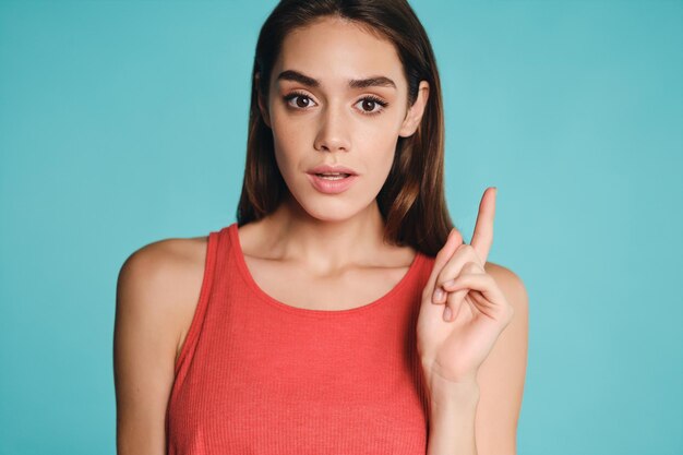 Portrait of beautiful casual girl having idea thoughtfully looking in camera over colorful background isolated