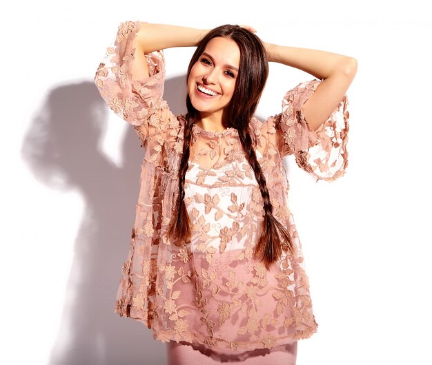 Portrait of beautiful caucasian smiling brunette woman model with double pigtails in bright pink summer stylish clothes 