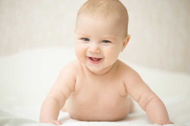 Portrait of a beautiful expressive laughing baby, holds head up