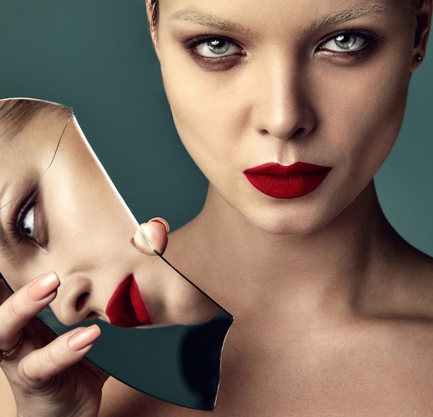 Portrait of beautiful fashion stylish brunette woman model with evening makeup and red lips in white jacket