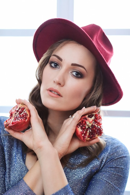 Free photo portrait of beautiful fashion woman with pomegranate fruit