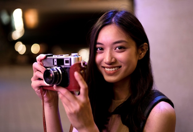 Portrait of beautiful female photographer in the city at night