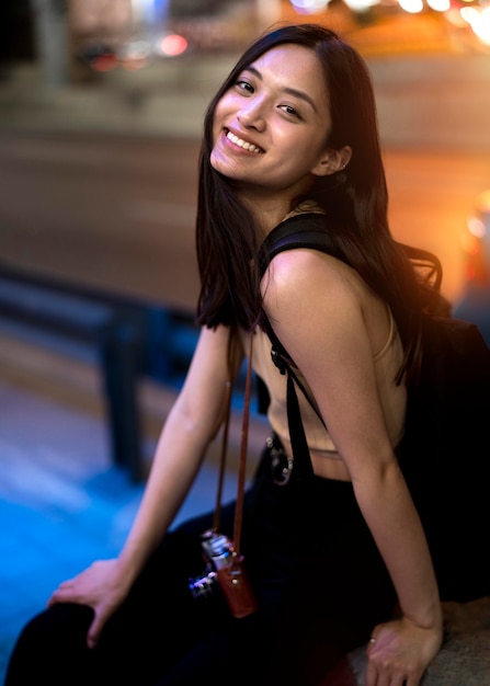 Free photo portrait of beautiful female photographer in the city at night