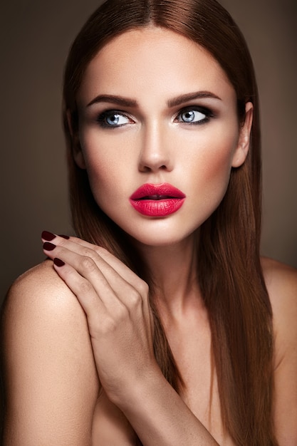 Portrait of beautiful girl model with evening makeup and romantic hairstyle. Red lips