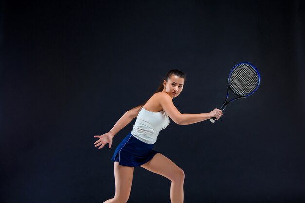 Free Photo portrait of beautiful girl tennis player with a racket on dark wall