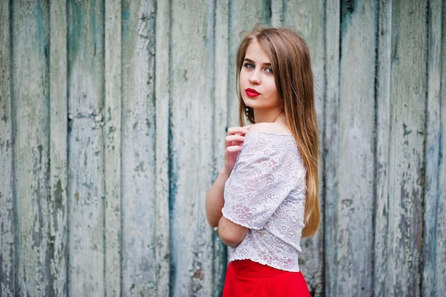 Portrait of beautiful girl with red lips against wooden background wear on red dress and white blouse