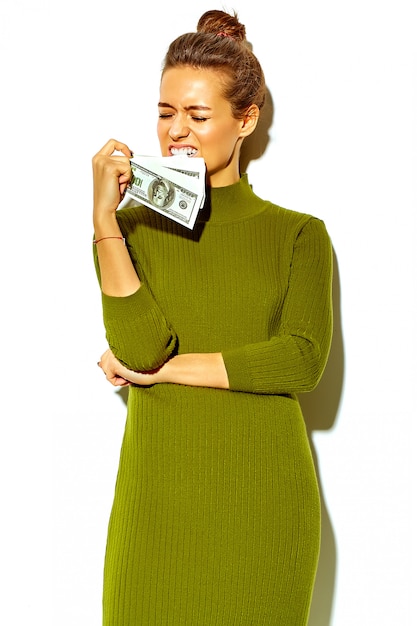 Free photo portrait of beautiful happy cute smiling brunette woman girl in casual green hipster summer clothes  isolated on white holding dollar banknote in mouth