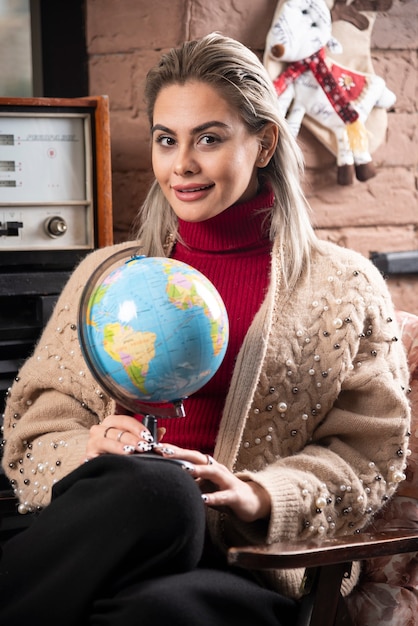 Free photo portrait of beautiful happy lady holding a world globe