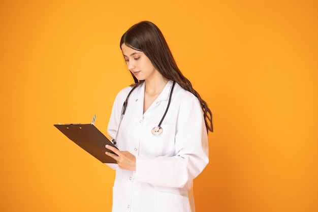 Portrait of beautiful mature woman doctor in lab coat holding document and looking at camera