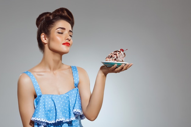 Free photo portrait of beautiful pin-up woman holding cake in hands