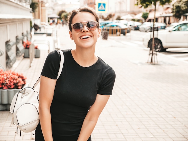 Free photo portrait of beautiful smiling model dressed in summer clothes. trendy girl posing in the street in sunglasses. funny and positive woman having fun