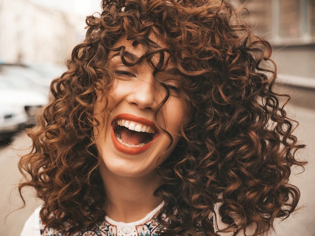 Portrait of beautiful smiling model with afro curls hairstyle.