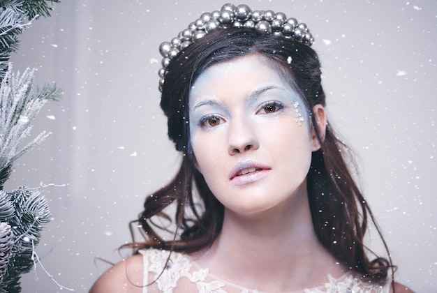 Free photo portrait of beautiful snow queen among falling snow