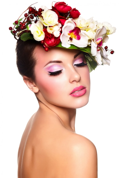 Portrait of beautiful stylish young woman with colorful flowers on head