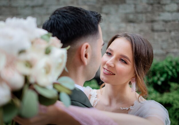 Portrait of a beautiful wedding couple who are almost kissing outdoors