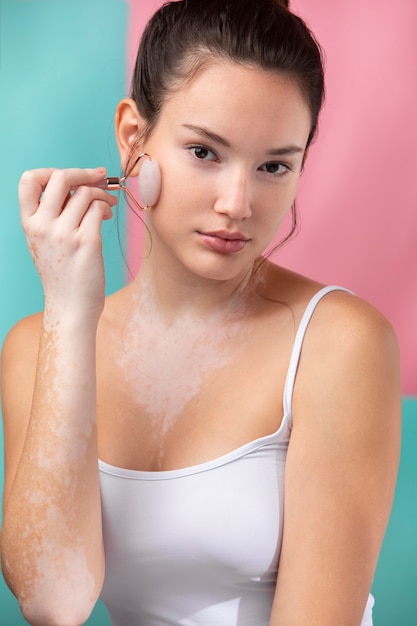 Free Photo portrait of a beautiful woman applying powder using a make-up brush