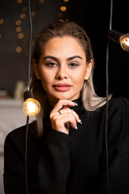 Portrait of beautiful woman in black sweater standing and posing