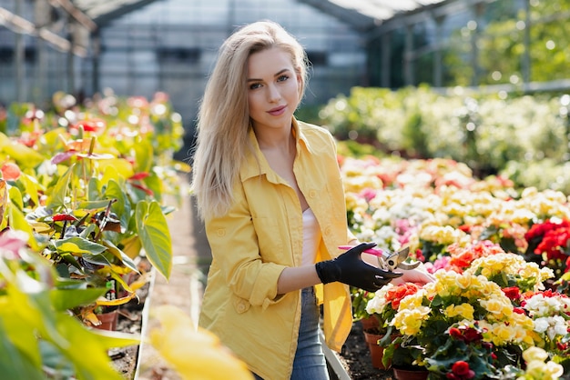 Portrait beautiful woman cares for flowers