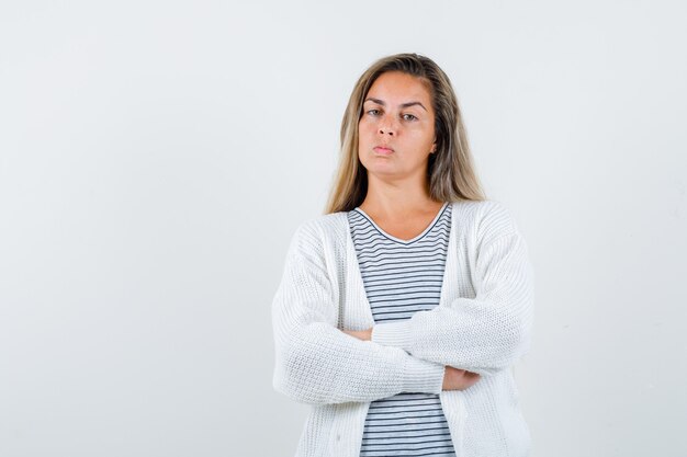 Portrait of beautiful woman holding arms folded in jacket and looking angry front view