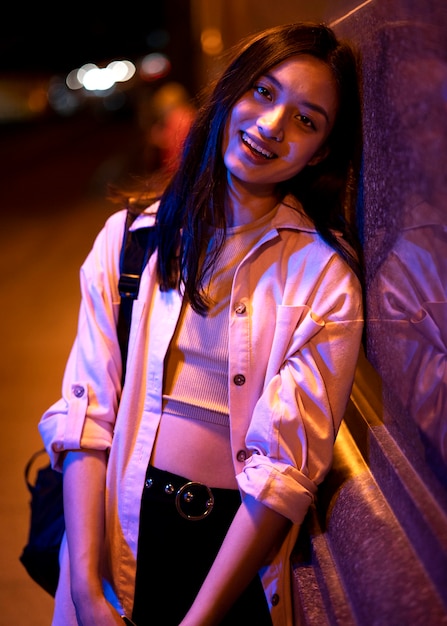 Free Photo portrait of beautiful woman at night in the city lights