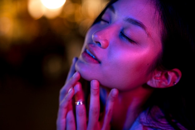 Free photo portrait of beautiful woman at night in the city lights