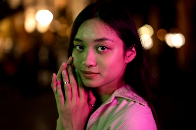 Portrait of beautiful woman at night in the city lights