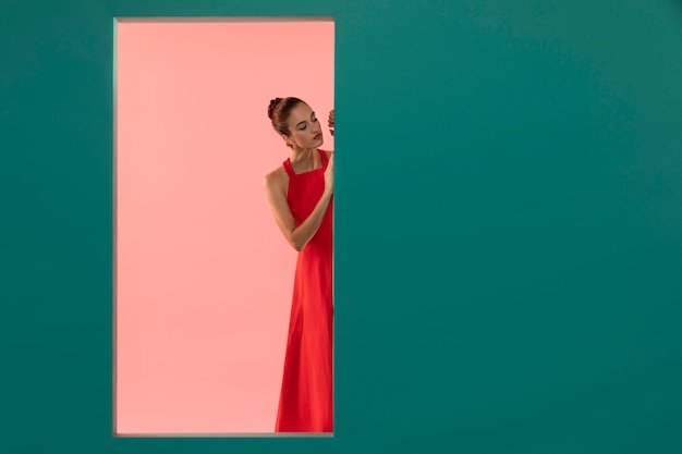 Portrait of beautiful woman posing in a flowy red dress with copy space