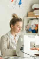 Free photo portrait of a beautiful woman at sewing machine