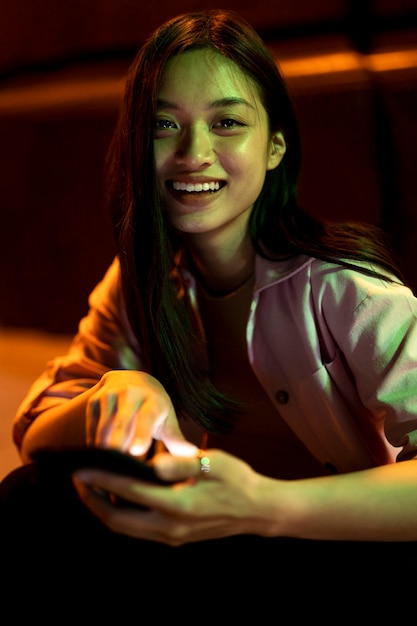 Free Photo portrait of beautiful woman using smartphone at night in the city lights