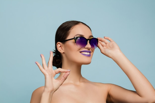 Portrait of beautiful woman with bright make-up and sunglasses. Stylish, fashionable make and hairstyle. Colors of summer.  Shows sign of nice.