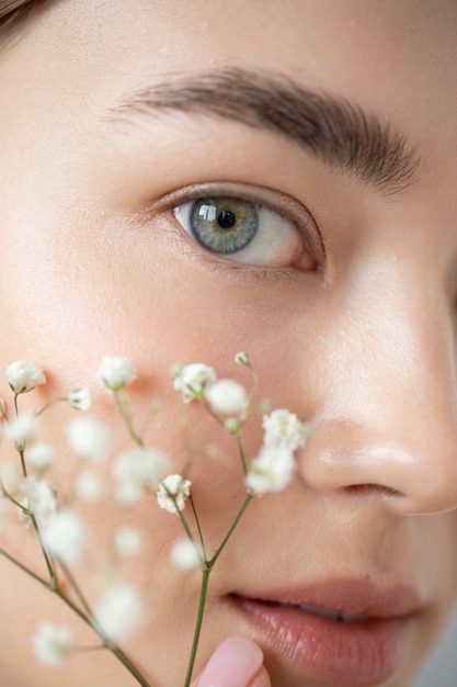 Free photo portrait of beautiful woman with clear skin posing with baby's breath flowers