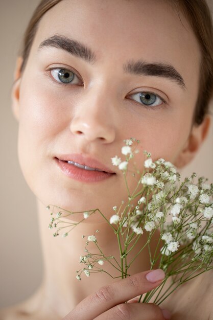 Portrait of beautiful woman with clear skin posing with baby's breath flowers