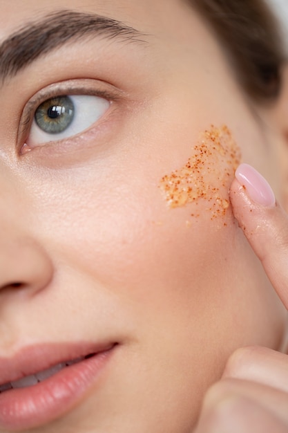 Portrait of beautiful woman with clear skin using face scrub