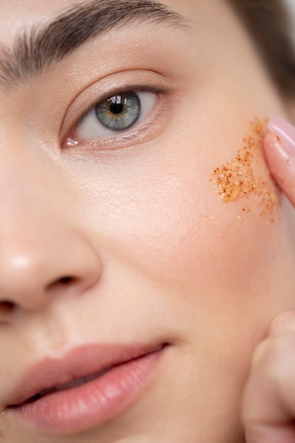 Portrait of beautiful woman with clear skin using face scrub