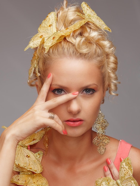 Free Photo portrait of beautiful woman with gold butterflys in decor. isolated on grey background