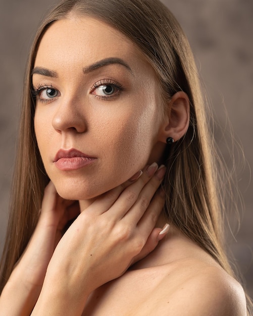 Portrait of a beautiful woman with her hands on her neck