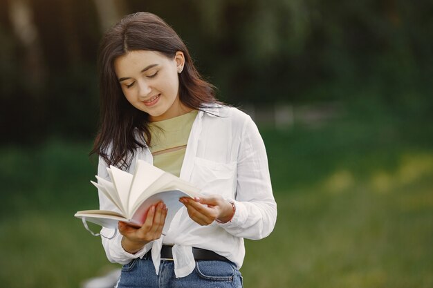 Portrait of beautiful woman. Woman read a book. Lady in a white shirt.