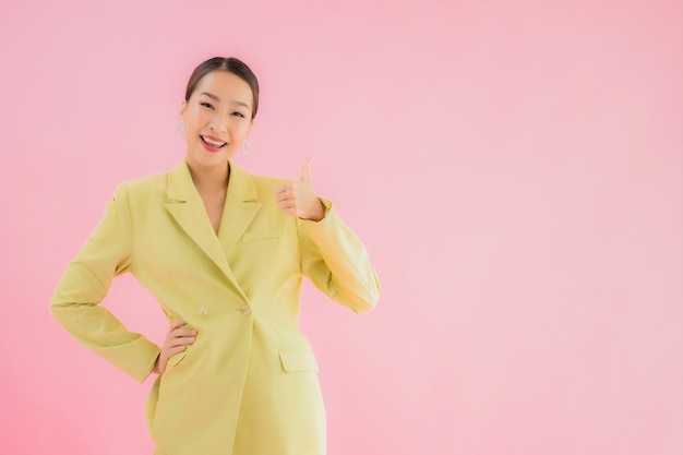 Portrait beautiful young asian business woman smile in action on pink color