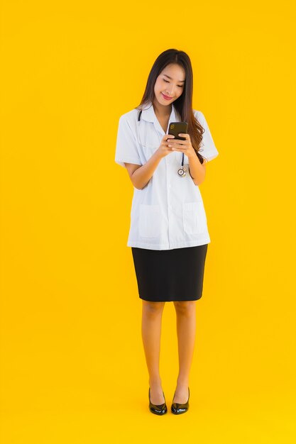 Portrait of beautiful young asian doctor woman uses smartphone