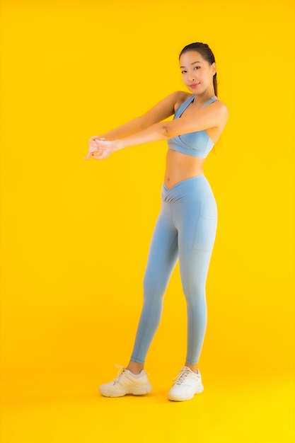 Portrait beautiful young asian sport woman ready for exercise on yellow