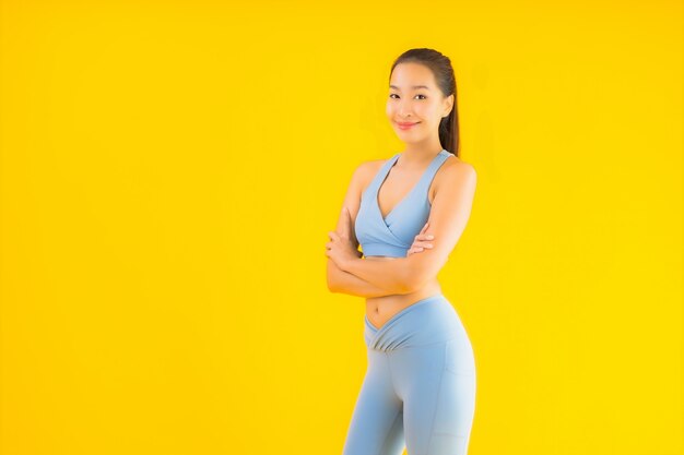 Portrait beautiful young asian sport woman ready for exercise on yellow