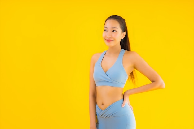 Portrait beautiful young asian sport woman ready for exercise on yellow