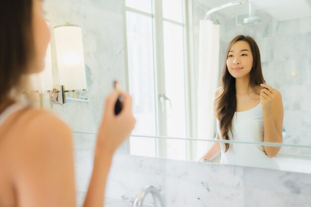 Portrait beautiful young asian woman checks up and makes up her face