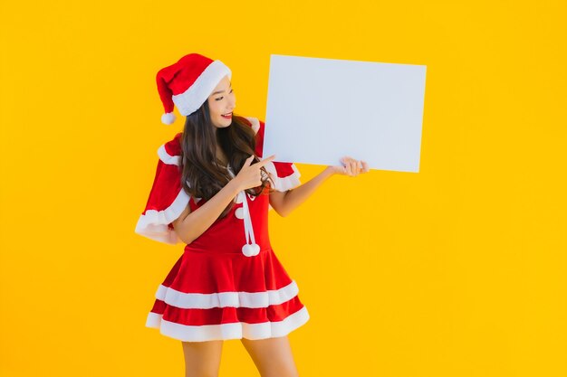 Portrait beautiful young asian woman christmas clothes and hat smile with empty board