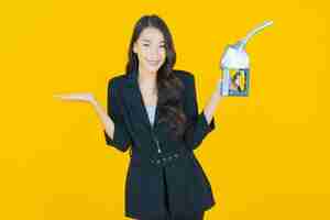 Free photo portrait beautiful young asian woman feul gas pump on yellow