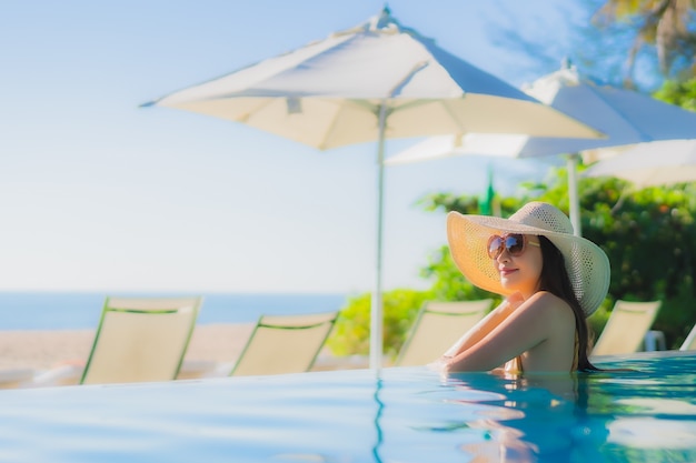 Portrait beautiful young asian woman happy smile relax around outdoor swimming pool in hotel resort